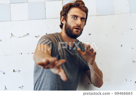Expressive young bearded man scared and nervous Expressive young bearded man scared and nervous 99466665