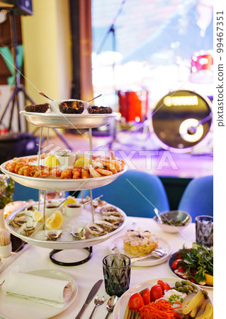 sea urchins, shrimp and shells with oysters on a platter with ice. sea urchins, shrimp and shells with oysters on a platter with ice. 99467351