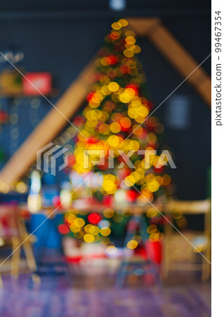 unfocused. a large Christmas tree decorated in a room with a black wall. blur unfocused. a large Christmas tree decorated in a room with a black wall. blur 99467354