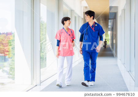 穿著磨砂服的醫護人員穿過醫療設施 穿著磨砂服的醫護人員穿過醫療設施 99467610