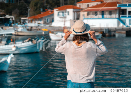 Girl in a hat travels, enjoys beautiful views on the seashore. Girl in a hat travels, enjoys beautiful views on the seashore. 99467613