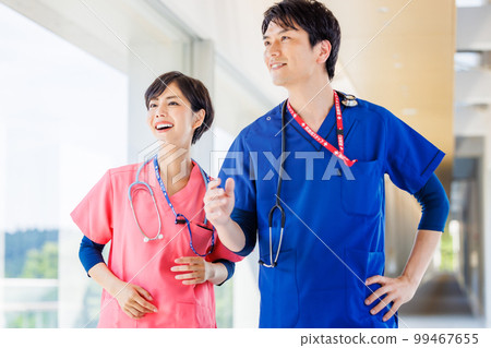 Healthcare workers in scrubs walking through a medical facility 99467655