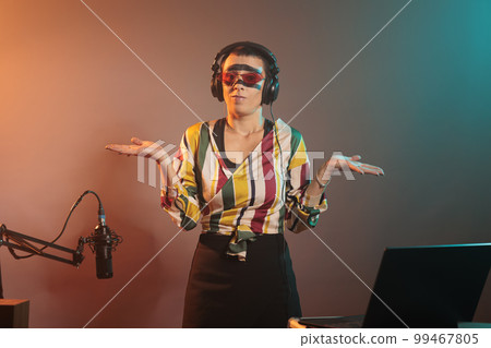 Female performer showing i dont know sign in studio, acting clueless and unsure about question. Young cool artist being confused and uncertain about unknown doubtful decision, shrugging. 99467805