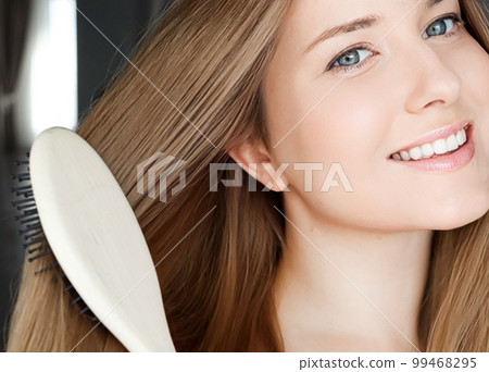 Beautiful happy woman combing her long hair. Beautiful happy woman combing her long hair. 99468295