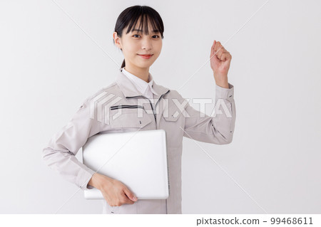 A woman in work clothes with a laptop A woman in work clothes with a laptop 99468611