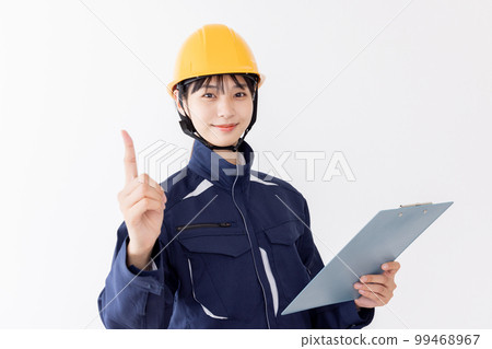 A woman in work clothes holding a clipboard Pointing A woman in work clothes holding a clipboard Pointing 99468967