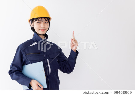 A woman in work clothes holding a clipboard Pointing 99468969