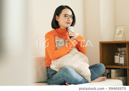 家里沙發上拿著智能手機的女人 99468970