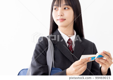 A high school girl studying efficiently with a word book while commuting to school 99469015