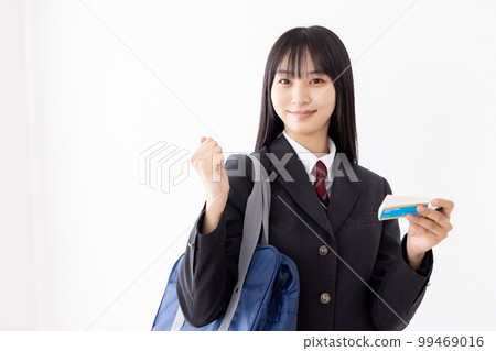 A high school girl studying efficiently with a word book while commuting to school 99469016
