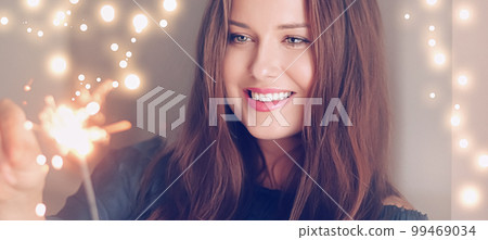 Holiday magic, Christmas and New Year celebration, happy woman with sparklers, portrait Holiday magic, Christmas and New Year celebration, happy woman with sparklers, portrait 99469034