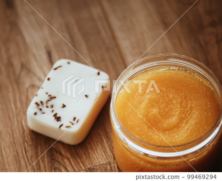 Citrus and honey orange body scrub jar on rustic wood background, beauty cosmetic and skincare product. Citrus and honey orange body scrub jar on rustic wood background, beauty cosmetic and skincare product. 99469294