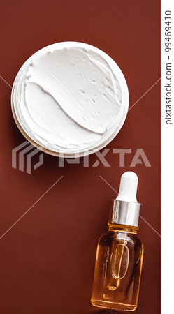 Beauty cosmetics and skincare product on chocolate background, flatlay. 99469410