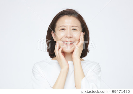 Senior woman doing skin care 99471450