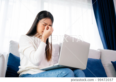 Office syndrome. Overworked tired young asian woman feeling headache 99472037