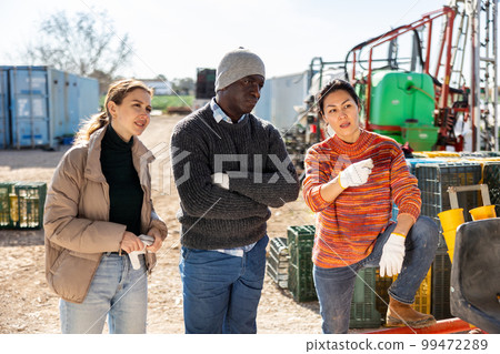 Multiracial farm workers talking about job outdoors Multiracial farm workers talking about job outdoors 99472289
