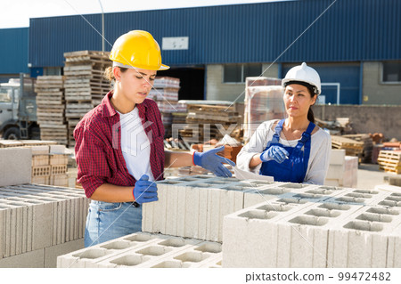 Couple of female wokers checking order list 99472482