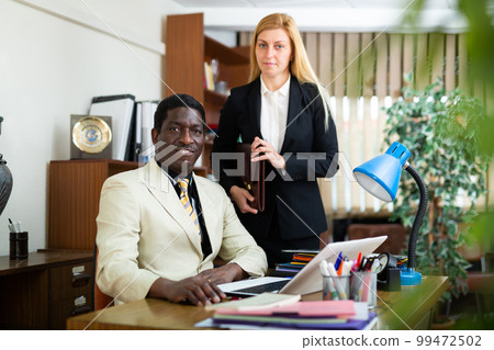 Businessman and businesswoman working together at company office 99472502