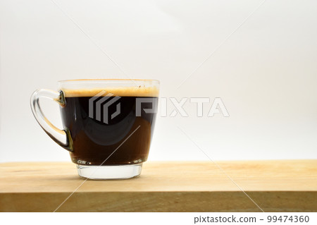 glass of black coffee put on wooden cutting board glass of black coffee put on wooden cutting board 99474360