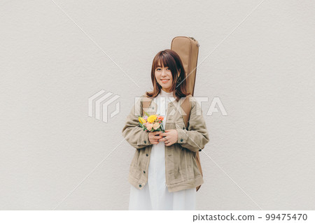 一個拿著吉他和鮮花的女人的照片 99475470