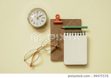 Notepad, diary, clock, eyeglasses, pencil, clip on yellow desk background. flay lay, top view, copy space Notepad, diary, clock, eyeglasses, pencil, clip on yellow desk background. flay lay, top view, copy space 99475578