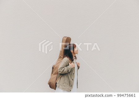 Photo of a woman with a guitar and flowers 99475661