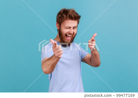 You are special. Portrait of positive happy bearded man pointing fingers at camera and looking with toothy smile, believes in you, motivation. Indoor studio shot isolated on blue background. 99477189