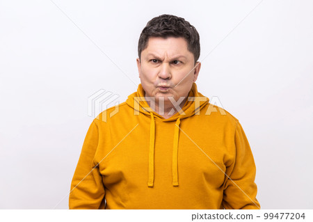 Funny amused middle aged man crossing his eyes looking crazy and stupid, fooling around, having fun, vision problems, wearing urban style hoodie. Indoor studio shot isolated on white background. 99477204