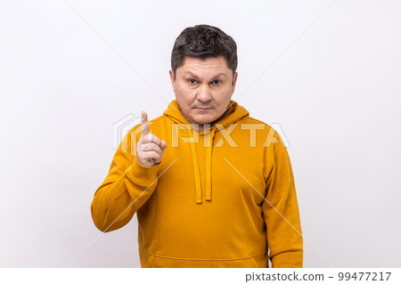 Strict angry middle aged man scolding for mistake, dissatisfied with behavior, blaming showing admonishing gesture, wearing urban style hoodie. Indoor studio shot isolated on white background. Strict angry middle aged man scolding for mistake, dissatisfied with behavior, blaming showing admonishing gesture, wearing urban style hoodie. Indoor studio shot isolated on white background. 99477217