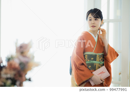 A woman in an orange visiting dress A woman in an orange visiting dress 99477991