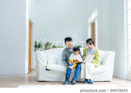 一家人坐在沙發上看電腦 99478045
