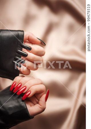 Hands of a young girl with black and red manicure on nails 99479319