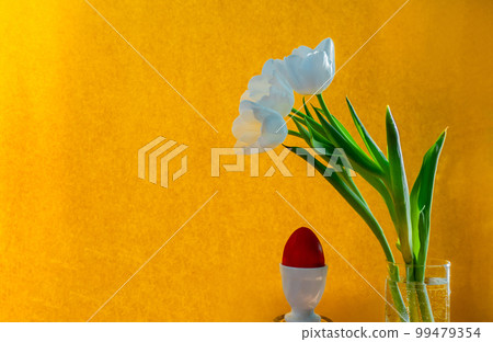 white tulip and red easter egg on a orange background white tulip and red easter egg on a orange background 99479354