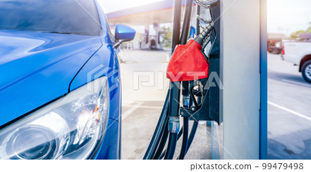 Blue luxury SUV car fueling at gas station. Refuel fill up with petrol gasoline. Petrol pump filling fuel nozzle in gas station. Petrol industry. Petrol price and oil crisis concept. Energy crisis. Blue luxury SUV car fueling at gas station. Refuel fill up with petrol gasoline. Petrol pump filling fuel nozzle in gas station. Petrol industry. Petrol price and oil crisis concept. Energy crisis. 99479498