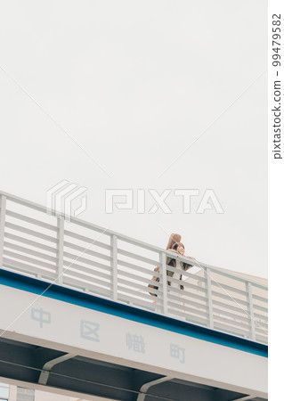 Photo of a woman holding a guitar standing on an overpass Photo of a woman holding a guitar standing on an overpass 99479582