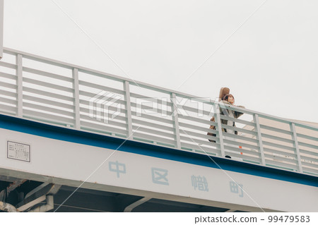 Photo of a woman holding a guitar standing on an overpass Photo of a woman holding a guitar standing on an overpass 99479583