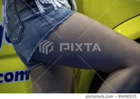 Model's sexy thighs standing next to the car 99480035