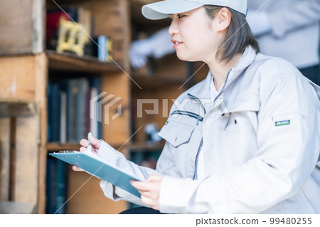 A female waste collector who checks the shelves 99480255