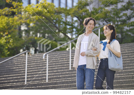 Young couple walking arm in arm Young couple walking arm in arm 99482157