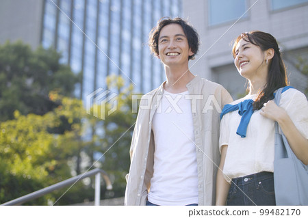 Young couple walking arm in arm Young couple walking arm in arm 99482170