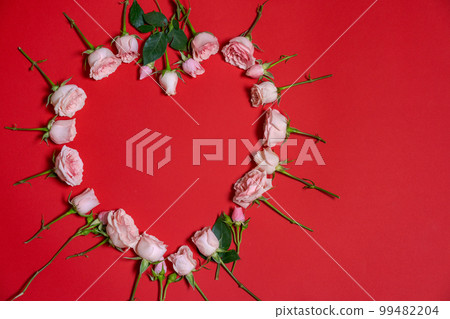 Pink roses in shape heart on red background. Valentine's day, advertising 99482204