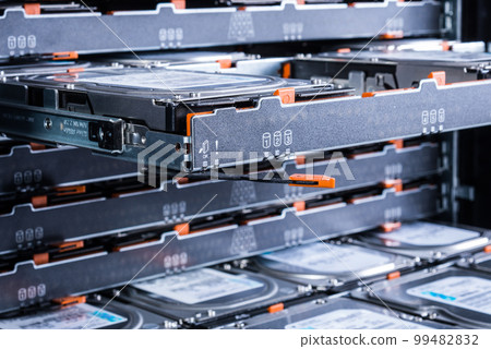 close up of hard disk drives inside hosting center - server rack filled with trays full of data storage drives 99482832