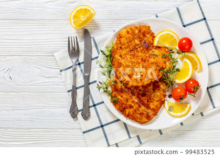 fried breaded chicken breast cutlets on plate 99483525