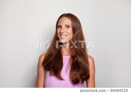 Beautiful mature woman portrait. Middle age woman with long brown hair smiling on white background 99484520