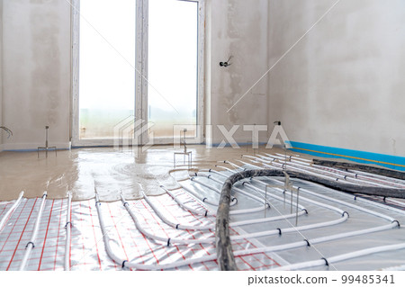 installation of concrete and anhydrite on underfloor heating in a room of a newly built family house installation of concrete and anhydrite on underfloor heating in a room of a newly built family house 99485341