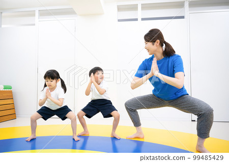 Exercising child and teacher Exercising child and teacher 99485429