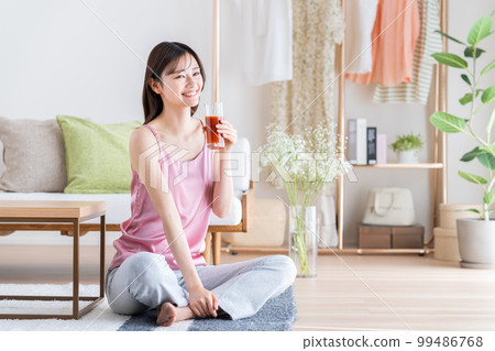A young woman drinking vegetable juice 99486768
