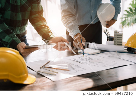 Engineer Teamwork Meeting, Drawing working on blueprint meeting for project working with partner on model building. 99487210
