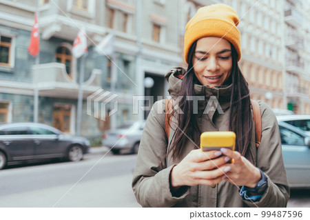 Woman tourist holding a mobile phone Woman tourist holding a mobile phone 99487596