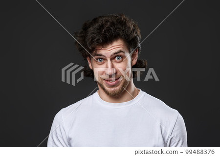 young bearded man in casual white t-shirt looking at the camera young bearded man in casual white t-shirt looking at the camera 99488376